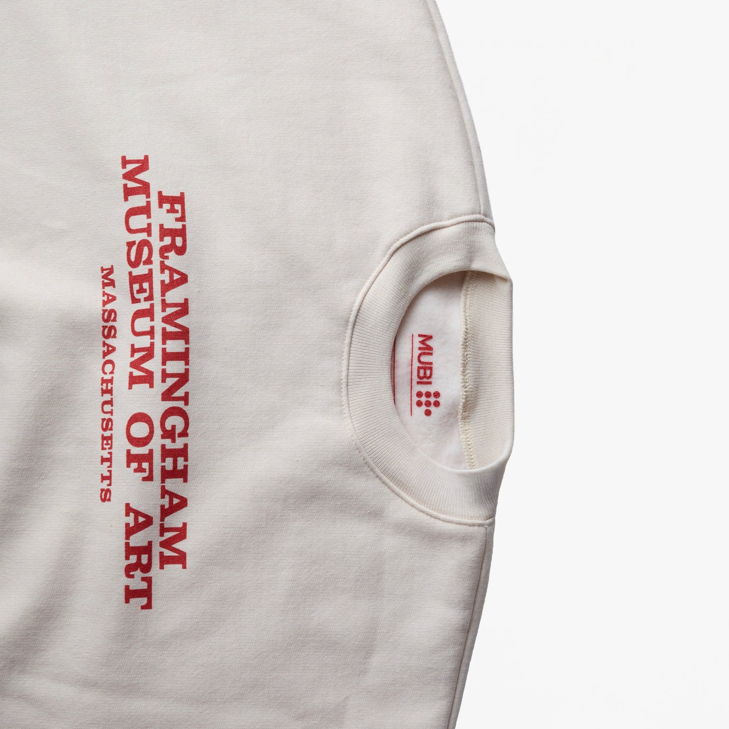 Close-up of THE MASTERMIND cream sweatshirt and the "FRAMINGHAM MUSEUM OF ART MASSACHUSETTS" on the front